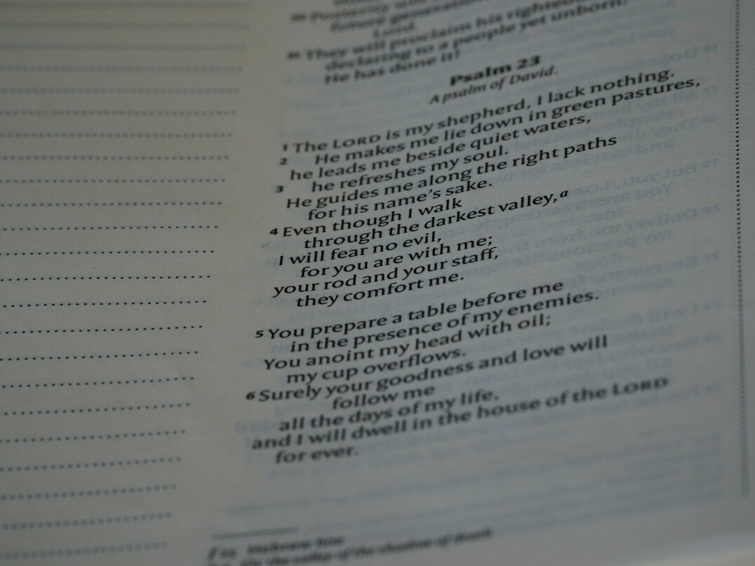 Notebook with a list of monthly expenses and a pen on a table