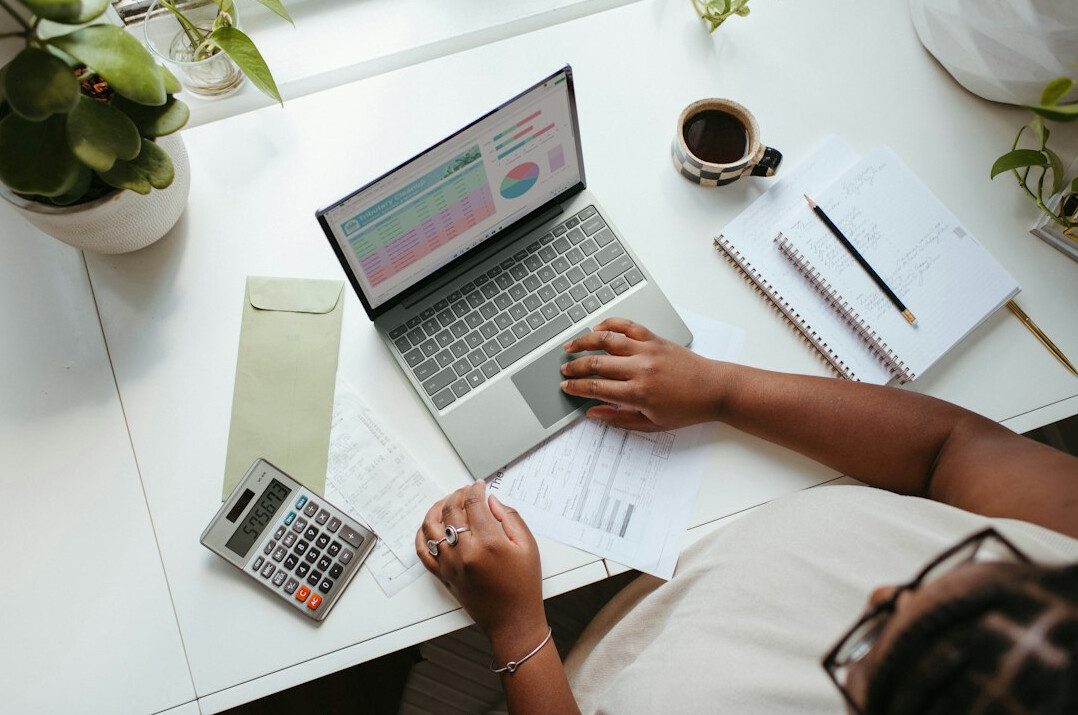 person calculating expenses on laptop